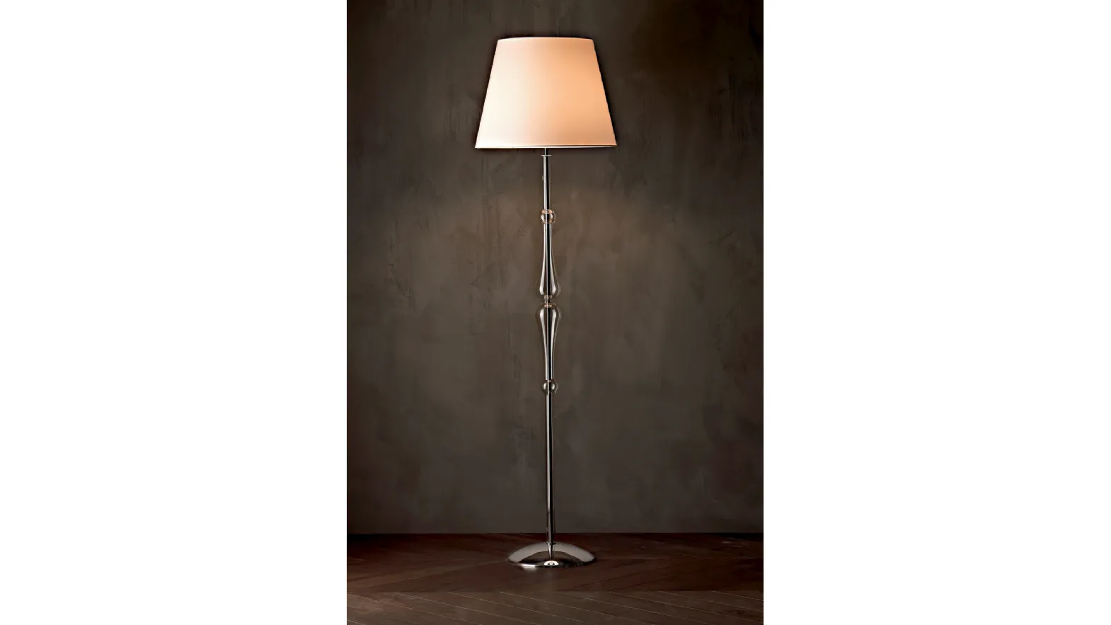 Lampada da terra Miss con struttura cromata,  stelo sagomato in pirex trasparente e paralume in tessuto di Le Fablier